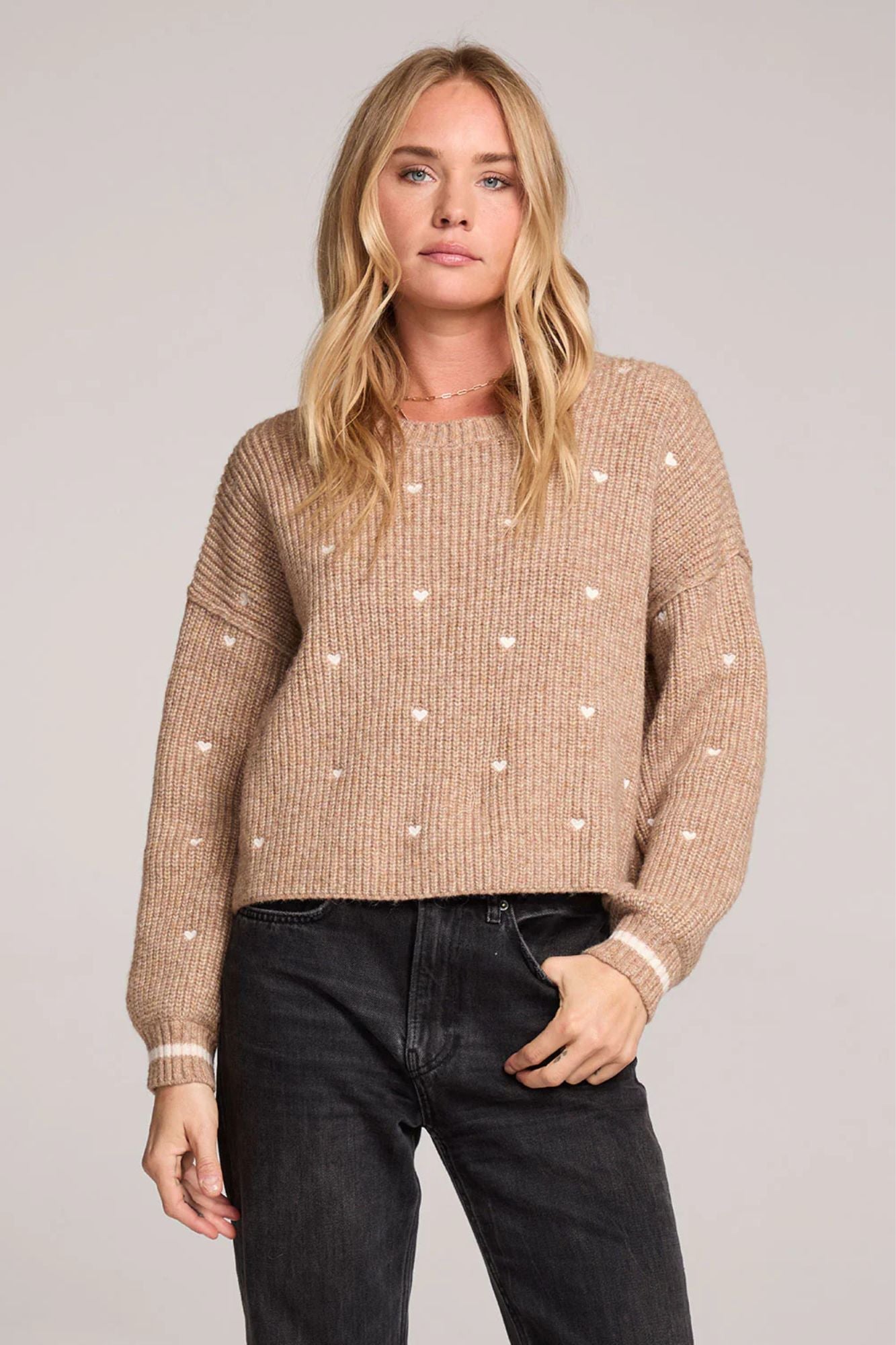 a beige sweater with white hearts